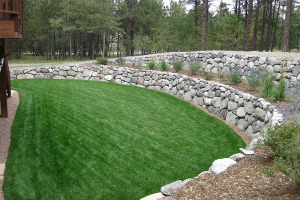 Beautiful backyard retaining walls with grey boulders in Black Forest.