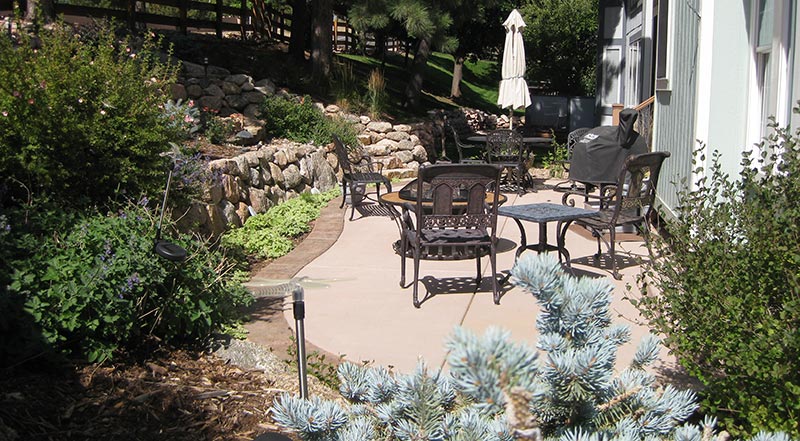 Terraced retaining walls create room for ample patio space and provide attractive planting beds in this small space.