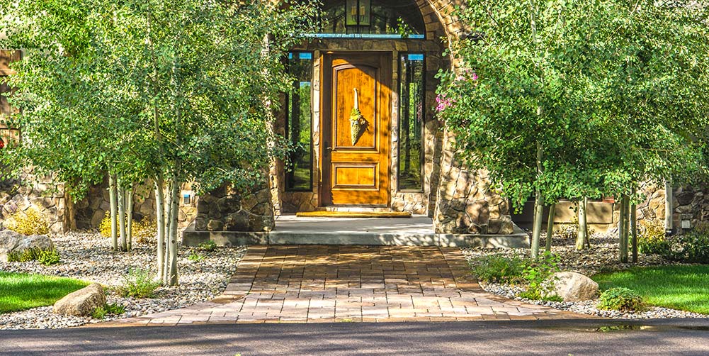 Learning how to install landscape pavers can help you create a front entry way like this Black Forest residence.