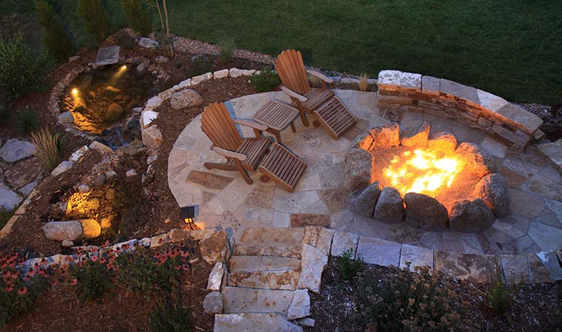 Outdoor patio with stone paving and fire pit.